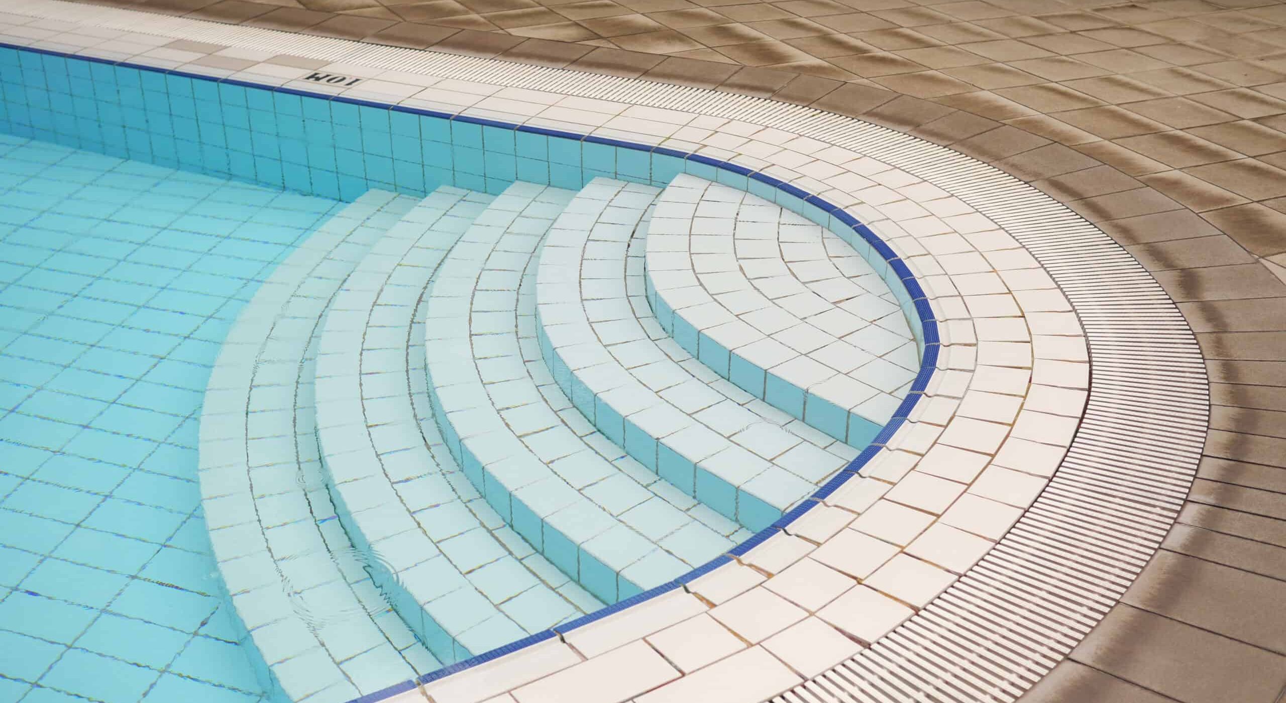 Beautiful swimming pool with tiled steps and surrounding deck.