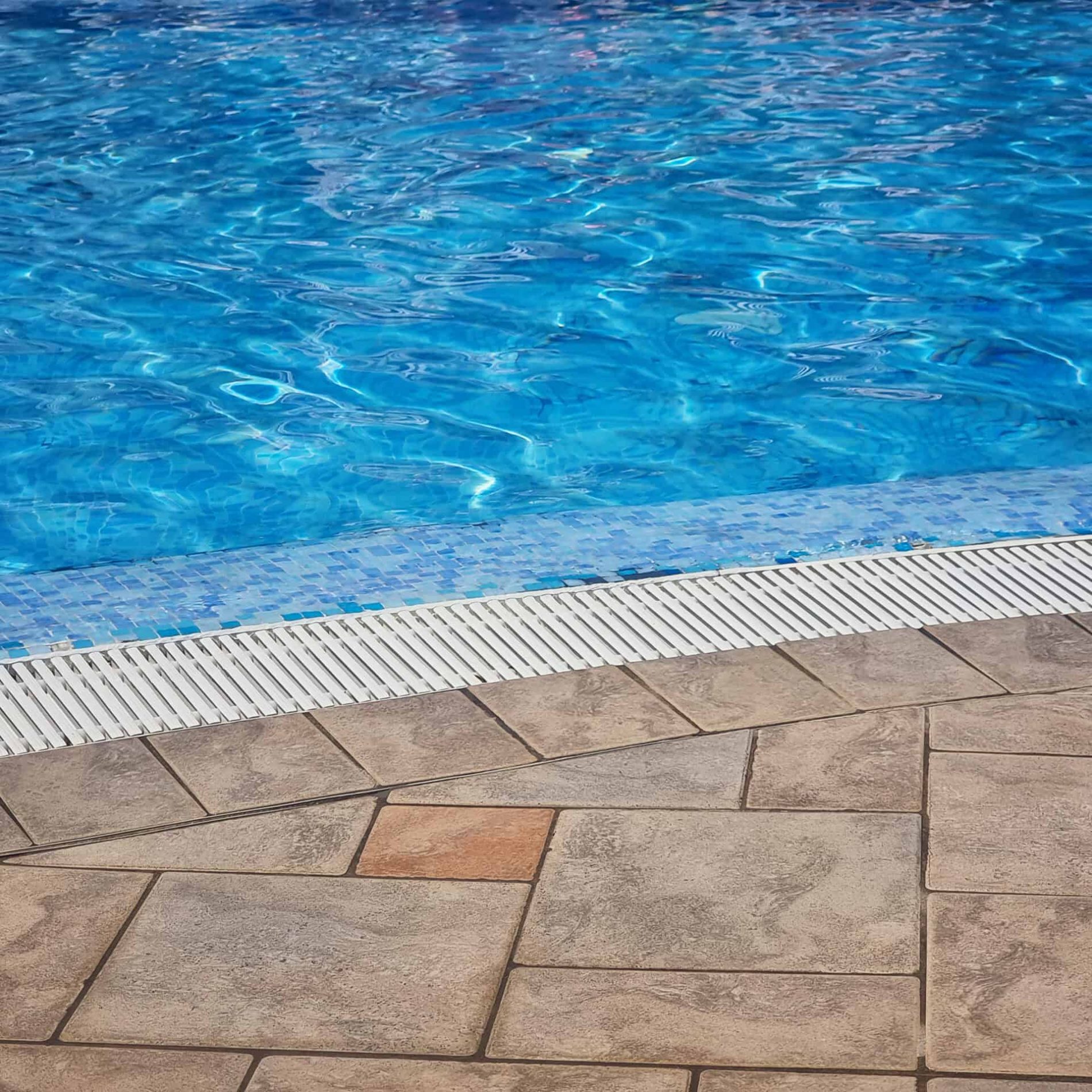 JMS Pool Plastering Corp Pool Deck Pool deck with textured concrete and water feature at JMS Pool Plastering.