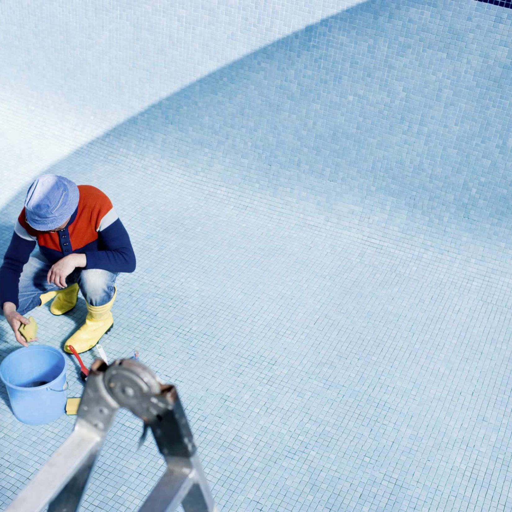 Pool plastering technician applying finishing touches to a swimming pool.