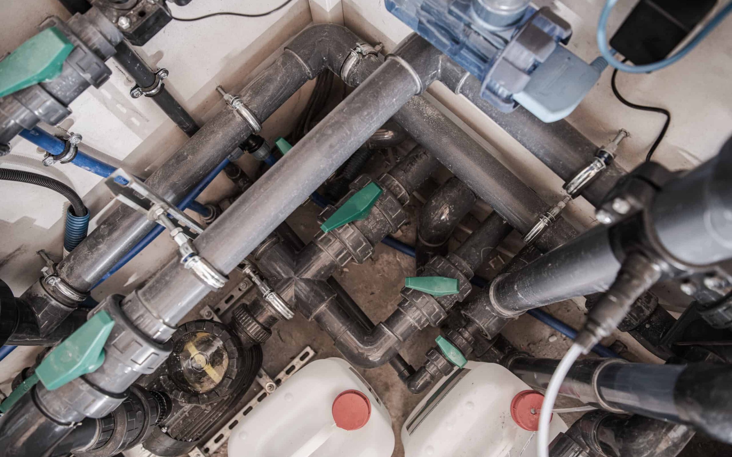 Complex pool plumbing system with pipes and valves for pool maintenance.