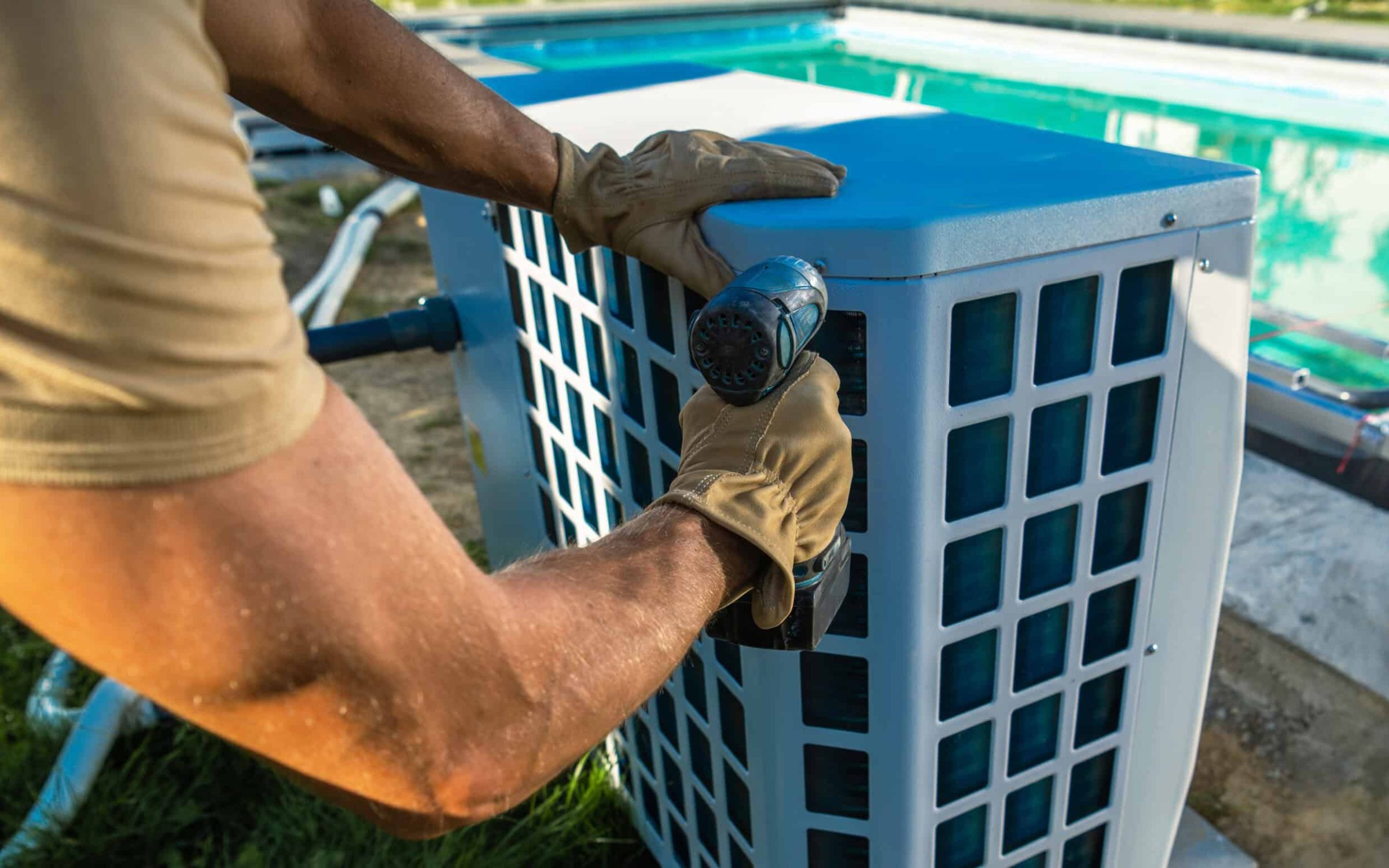 Technician servicing an outdoor air conditioning unit for pool area cooling.